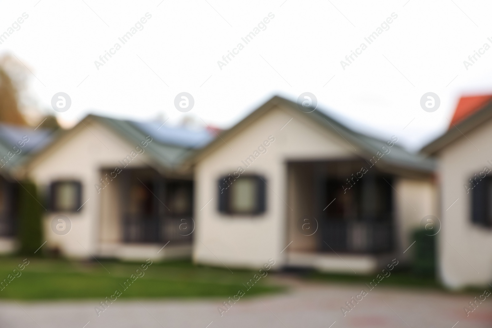 Photo of Beautiful cottage houses outdoors, blurred view. Real estate for rent