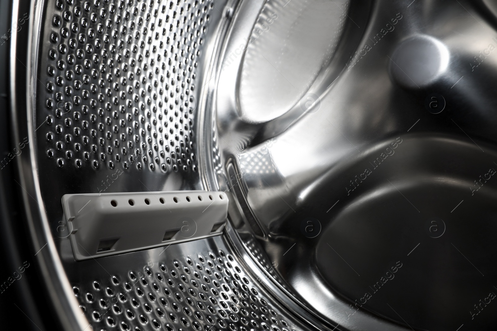 Photo of Empty washing machine drum, closeup. Laundry day