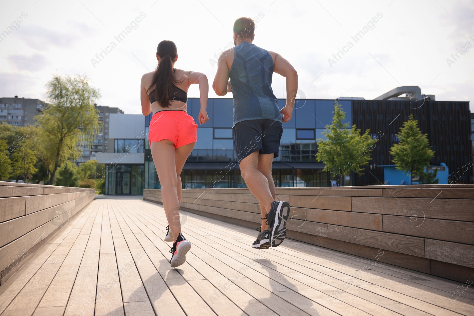 Photo of Healthy lifestyle. Couple running outdoors on sunny day, low angle view