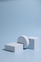 Photo of Scene for product presentation. Podiums of different geometric shapes on light blue background
