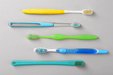 Many different toothbrushes on light background, flat lay