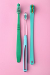 Many different toothbrushes on pink background, flat lay