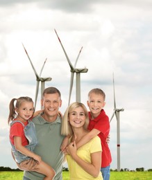 Happy family with children and view of wind energy turbines