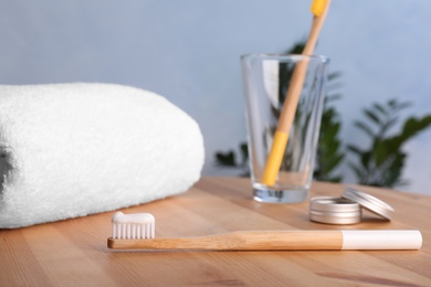 Photo of Set with bamboo toothbrushes and towel on table