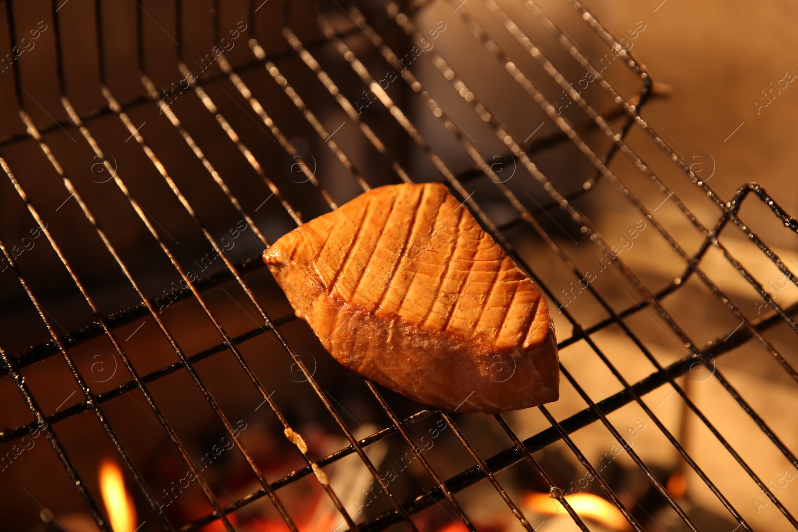 Photo of Grilling basket with tuna in oven, closeup