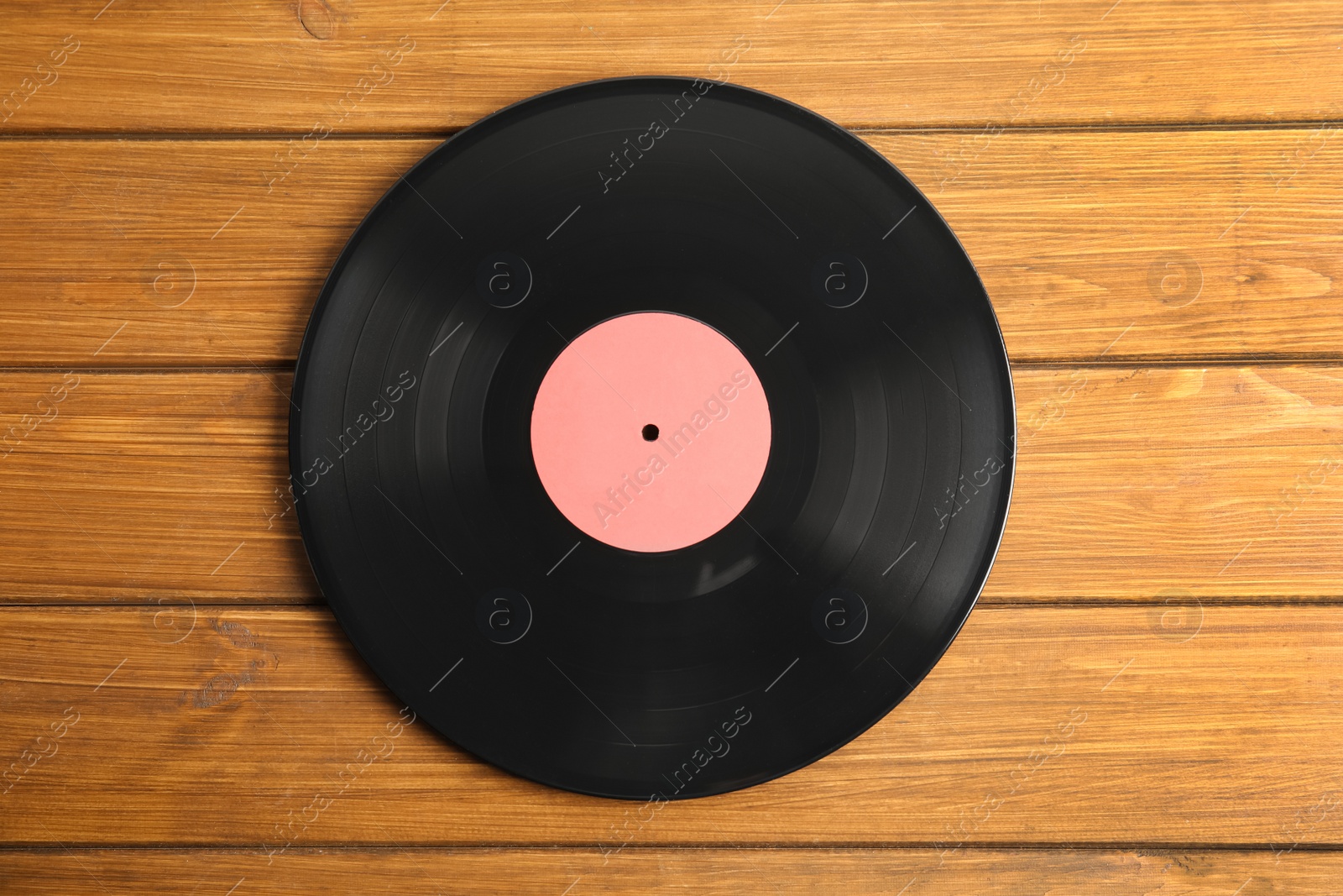 Photo of Vintage vinyl record on wooden table, top view