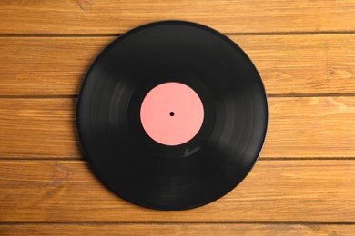 Photo of Vintage vinyl record on wooden table, top view
