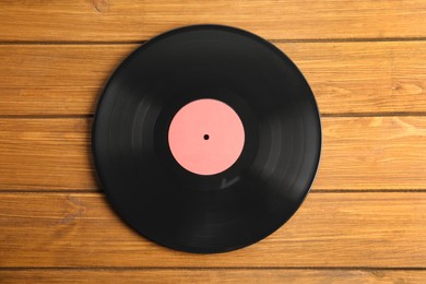 Vintage vinyl record on wooden table, top view