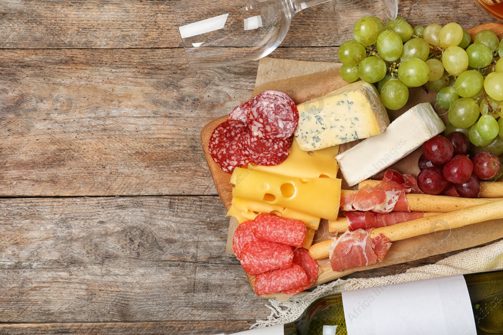 Photo of Flat lay composition with wine, snacks and space for text on wooden background