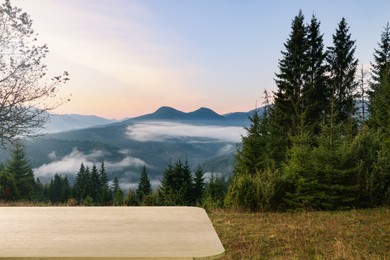 Image of Empty wooden surface and picturesque view of beautiful mountain landscape covered with fog
