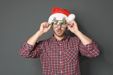 Photo of Young man in Christmas hat on grey background