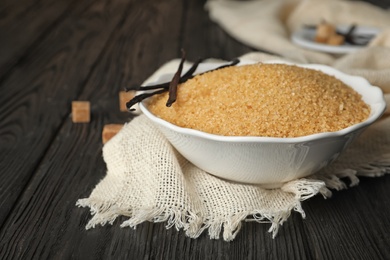 Photo of Bowl with brown vanilla sugar on wooden table