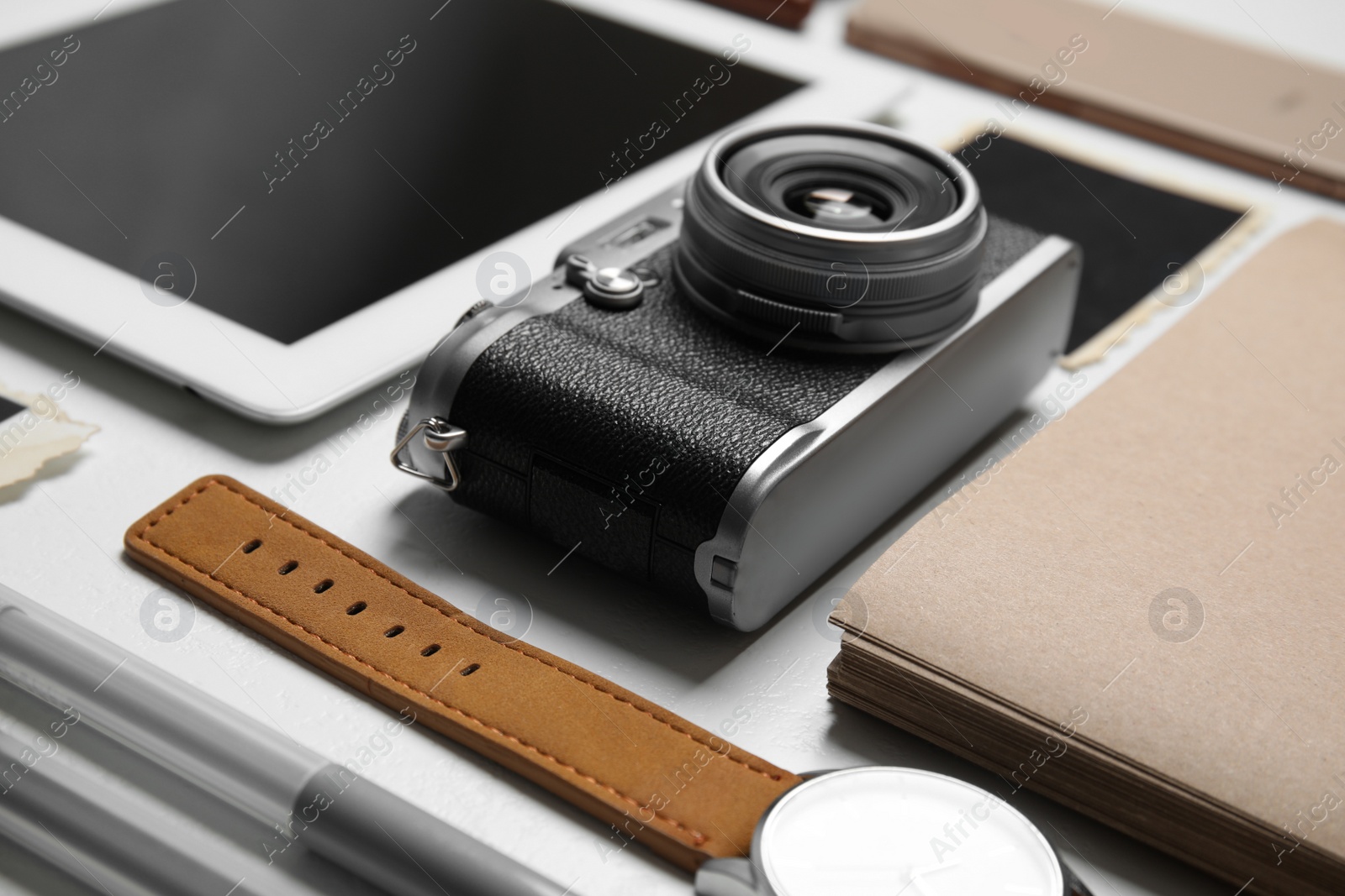 Photo of Composition with vintage camera and notebook on white table, closeup. Designer's workplace