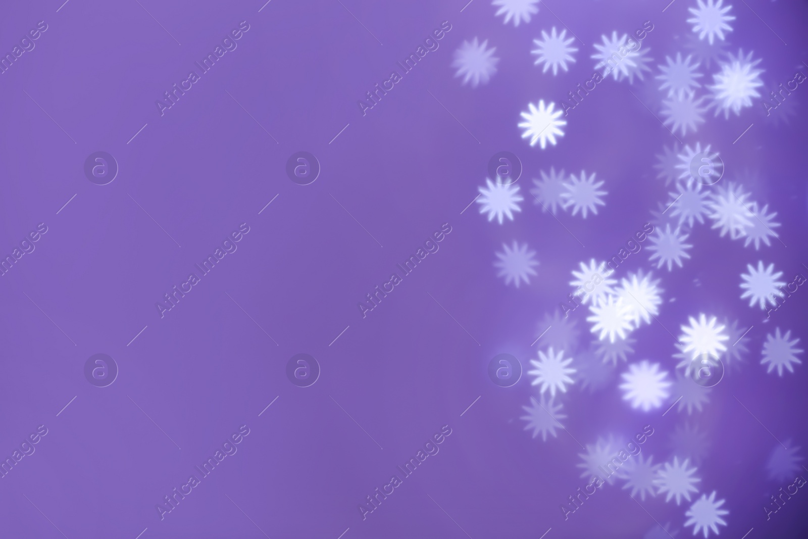 Photo of Beautiful snowflake shaped lights on purple background, space for text