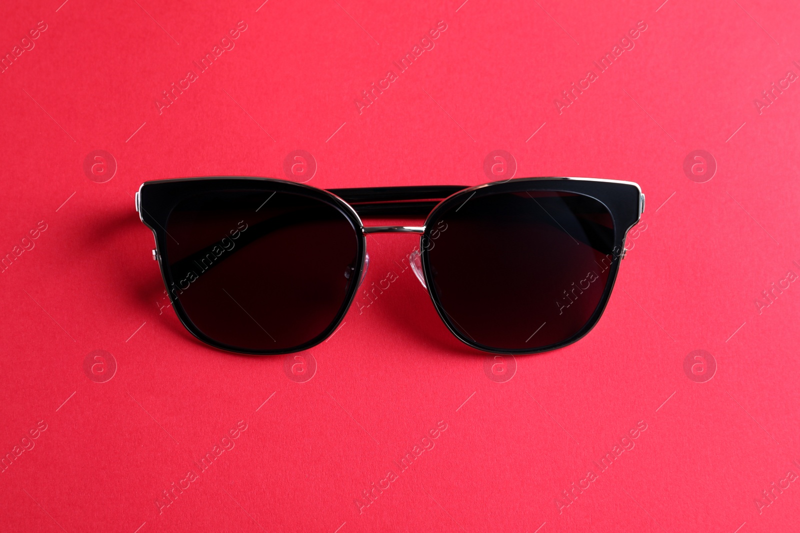 Photo of Stylish sunglasses on pink background, top view