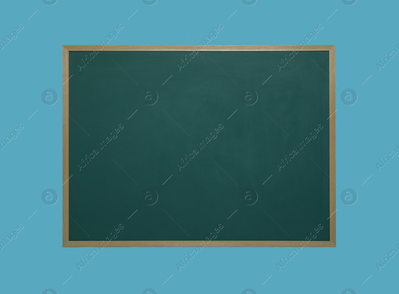 Photo of Clean green chalkboard on light blue background