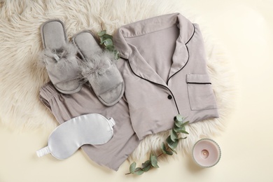 Photo of Flat lay composition with house slippers, sleeping mask and pajamas on light background