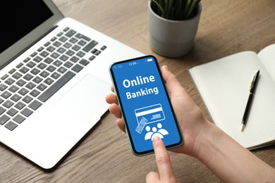 Image of Woman using online banking application on smartphone indoors, closeup