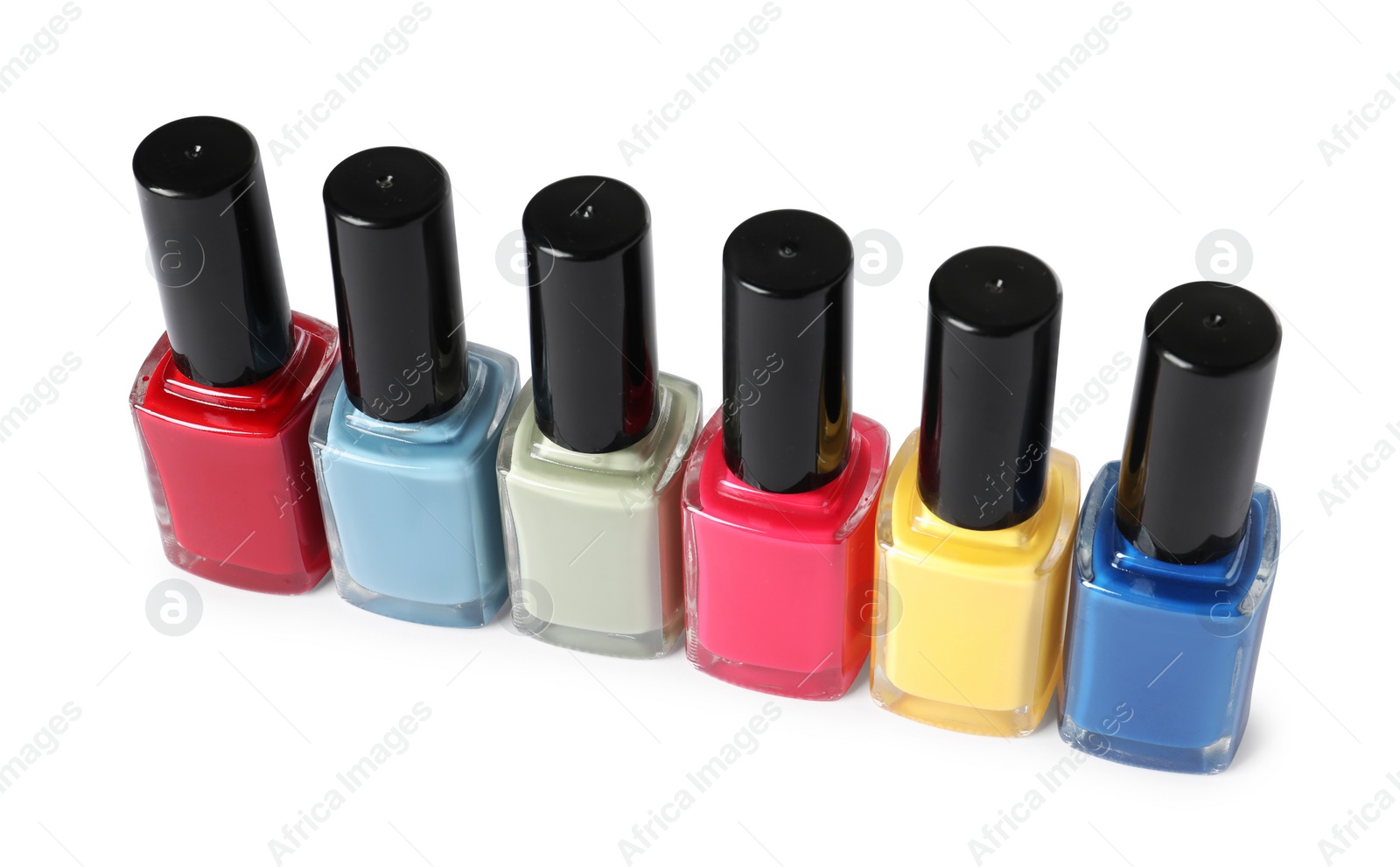 Photo of Bright nail polishes in bottles isolated on white