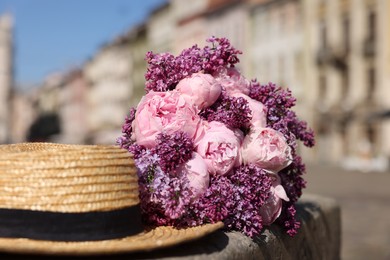 Bouquet of beautiful spring flowers and straw hat outdoors