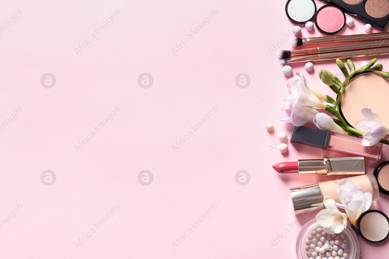 Photo of Different makeup products with flowers on color background. Space for text