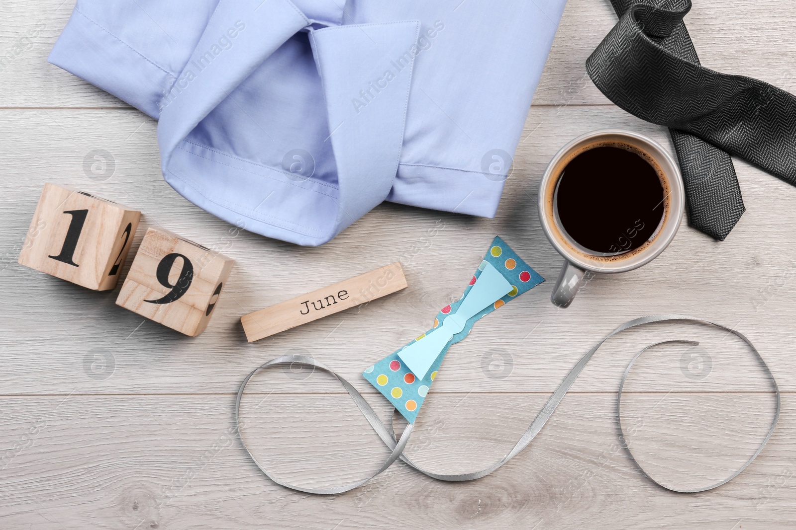 Photo of Composition with calendar, shirt and coffee on wooden background. Father's day celebration