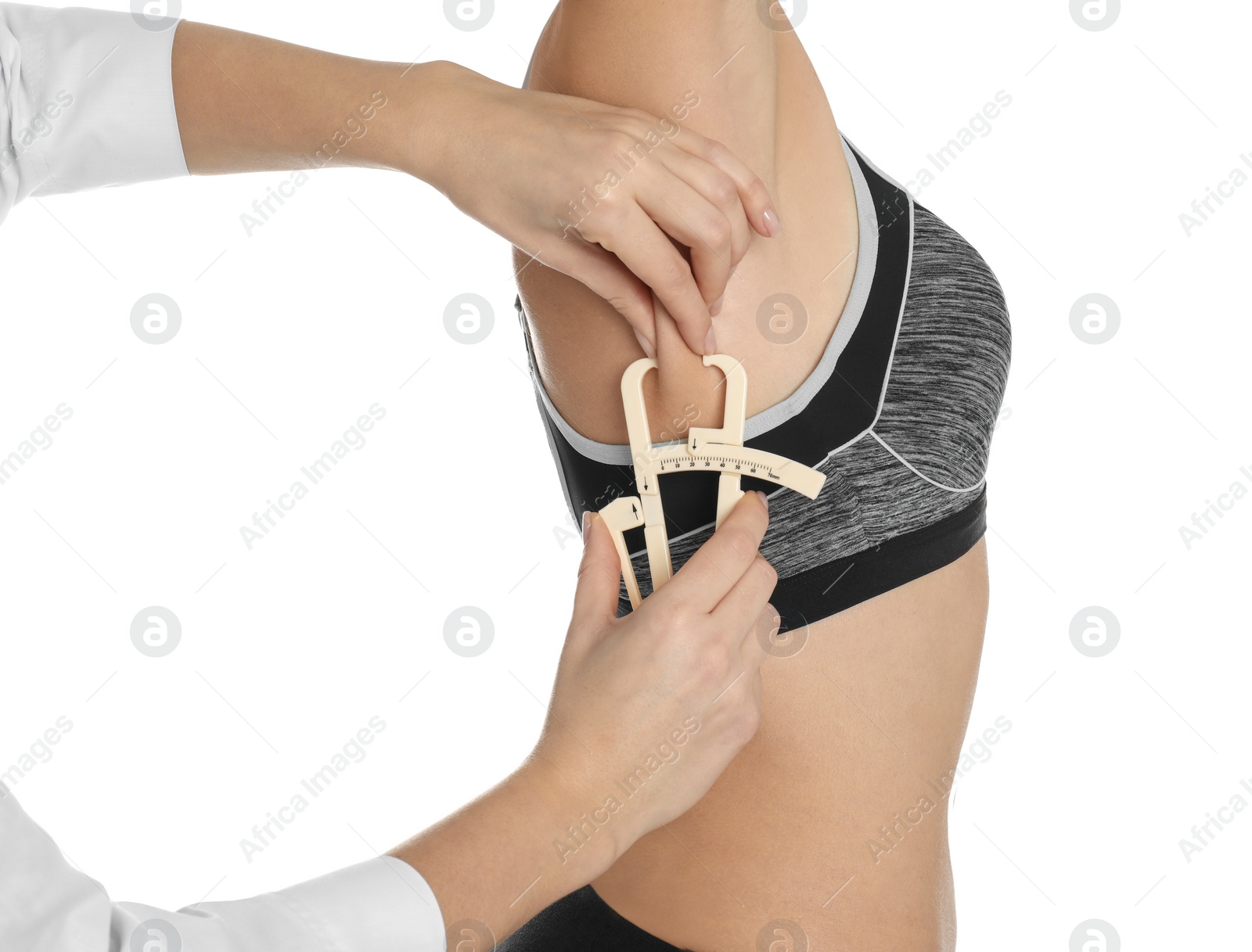 Photo of Nutritionist measuring woman's fat layer with caliper on white background, closeup