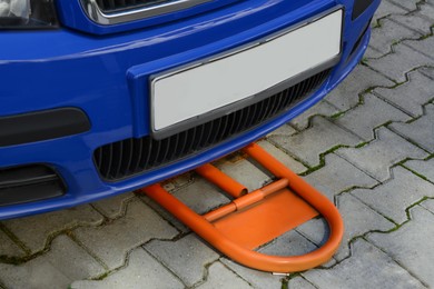 Photo of Parking barrier under car on pavement outdoors, closeup