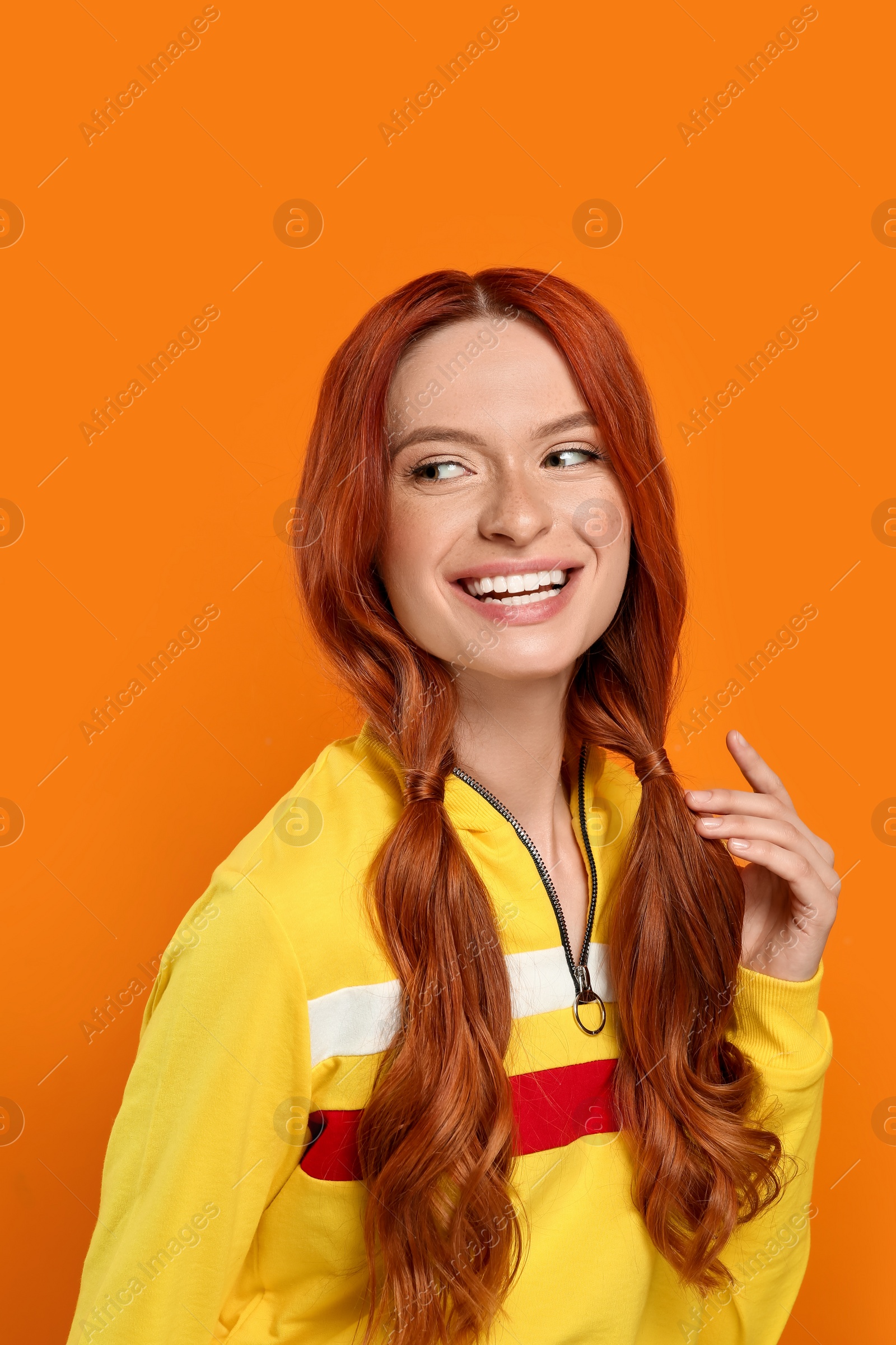 Photo of Portrait of smiling beautiful woman on orange background