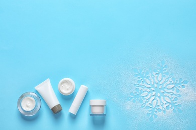 Photo of Set of cosmetic products on blue background, flat lay with space for text. Winter care