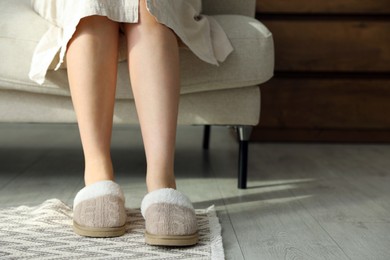 Photo of Woman in soft slippers at home, closeup