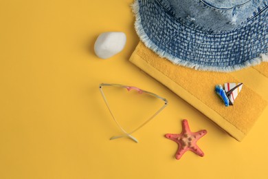 Photo of Flat lay composition with beach accessories on orange background, space for text