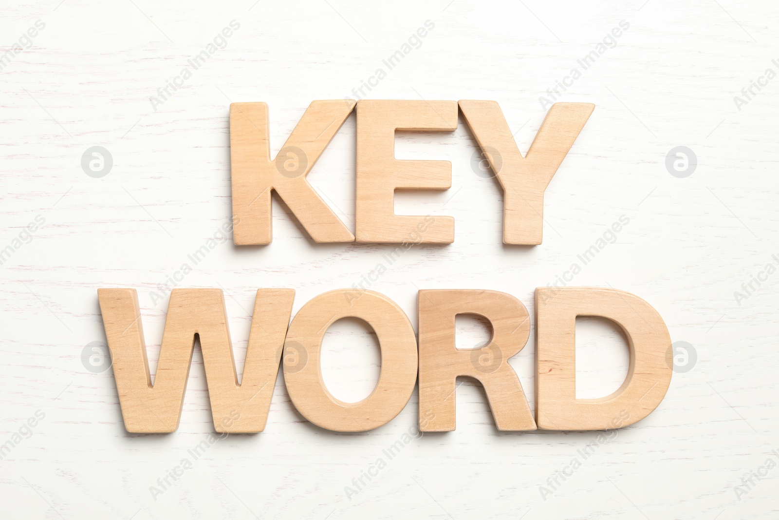 Photo of Word KEYWORD made of wooden letters on white background, flat lay