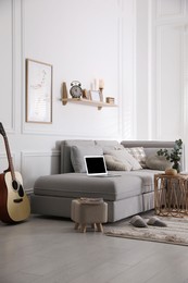 Living room with comfortable grey sofa and stylish interior elements