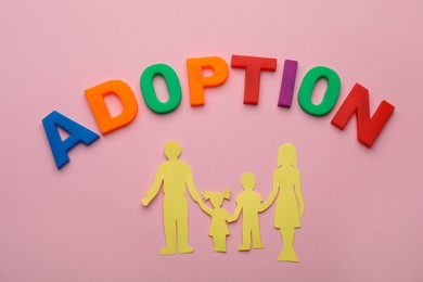 Photo of Family figure and word Adoption on pink background, flat lay