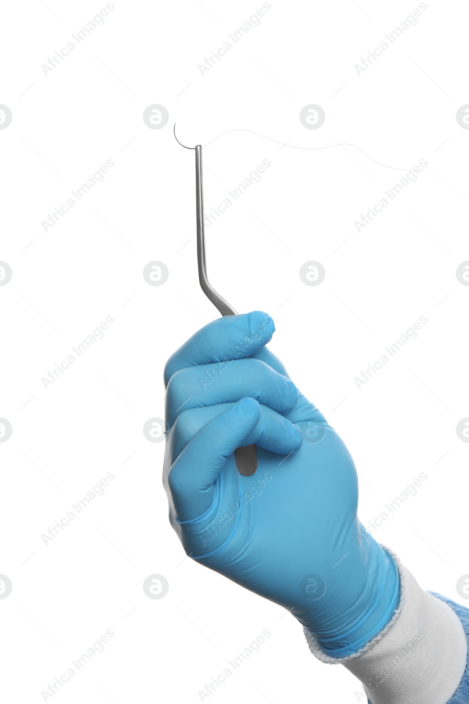 Photo of Doctor holding needle with suture thread on white background, closeup. Medical equipment