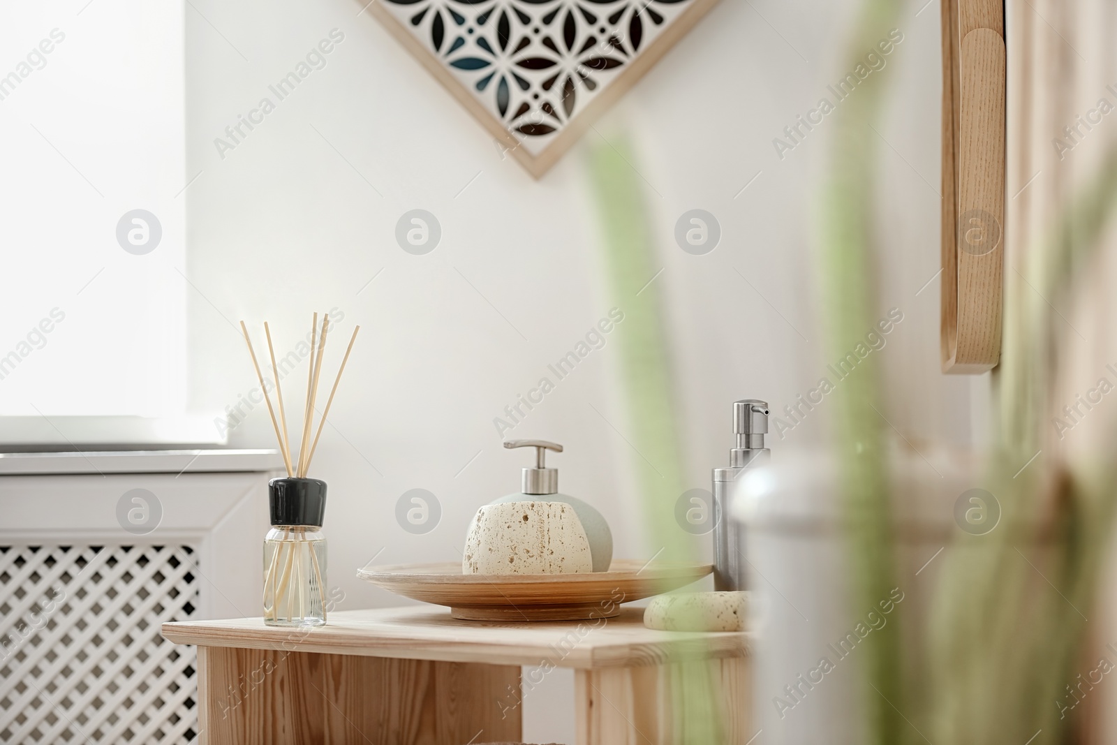 Photo of Aromatic reed air freshener and toiletries on table indoors