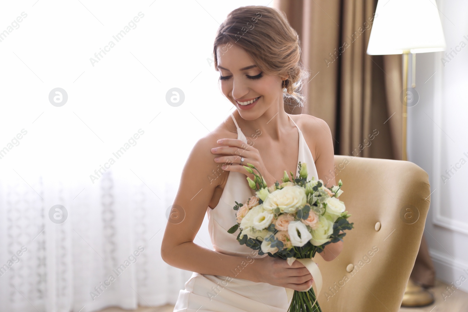 Photo of Young bride with beautiful wedding bouquet indoors