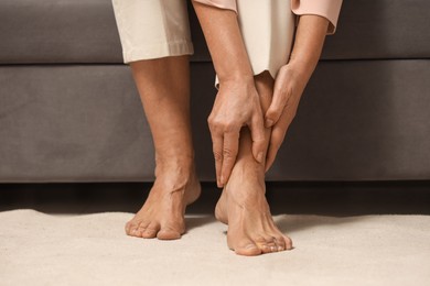 Photo of Mature woman suffering from pain in leg indoors, closeup. Rheumatism symptom