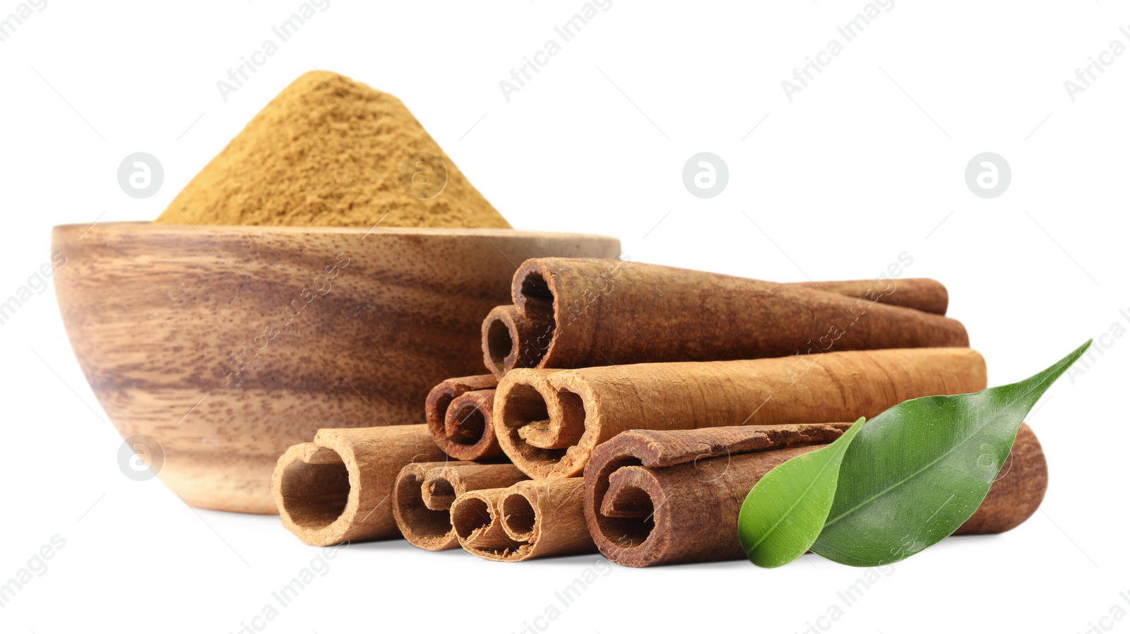 Photo of Dry aromatic cinnamon sticks, powder and green leaves isolated on white