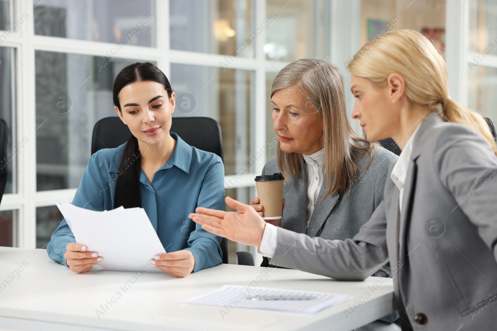 Photo of Lawyers working together with documents at table in office