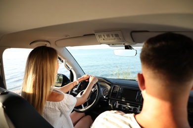 Photo of Couple in car near sea on sunny day. Summer trip