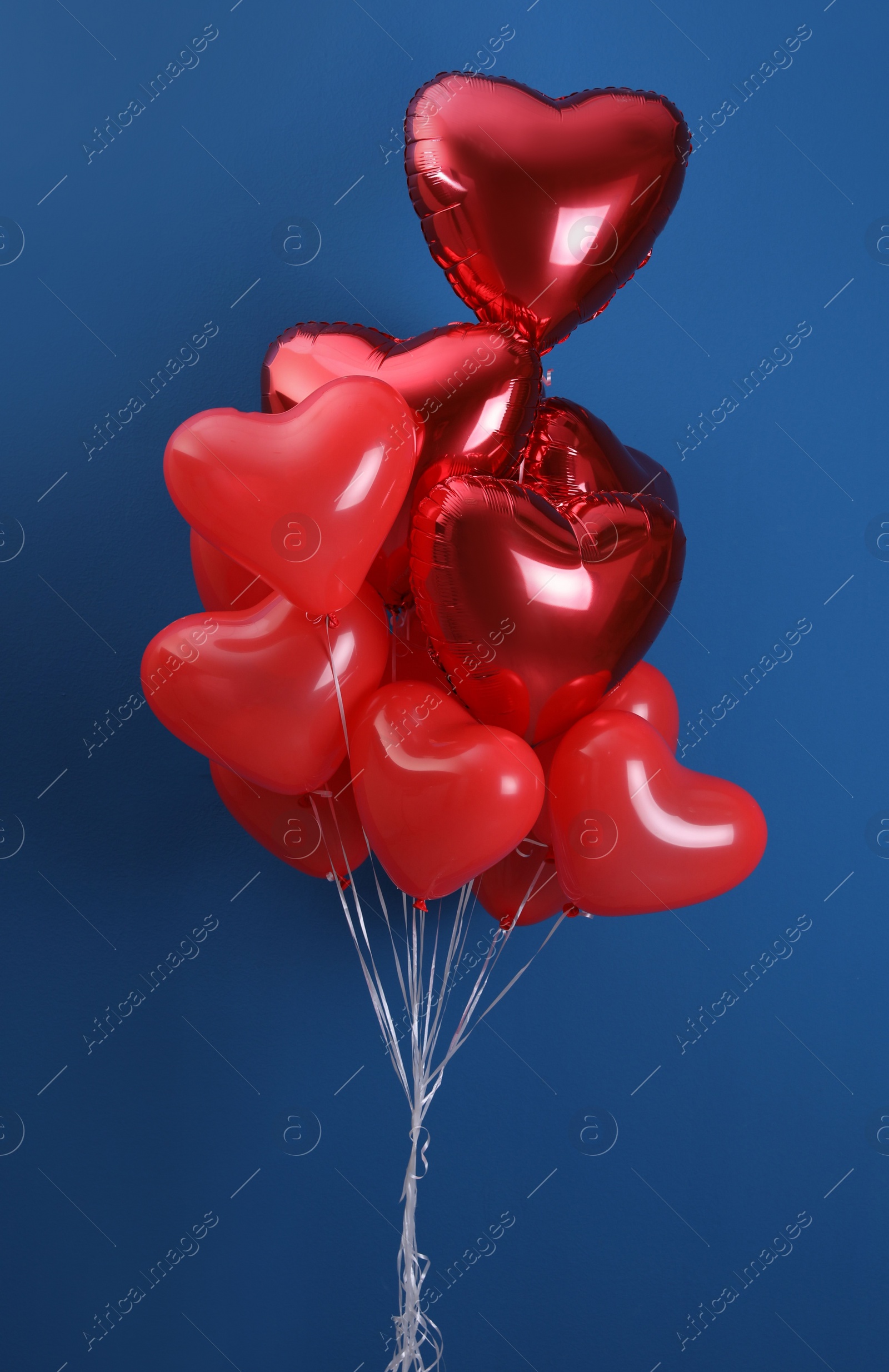 Photo of Bunch of heart shaped balloons on blue background. Valentine's day celebration