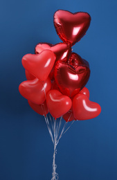 Photo of Bunch of heart shaped balloons on blue background. Valentine's day celebration