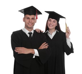 Photo of Happy students in academic dresses on white background
