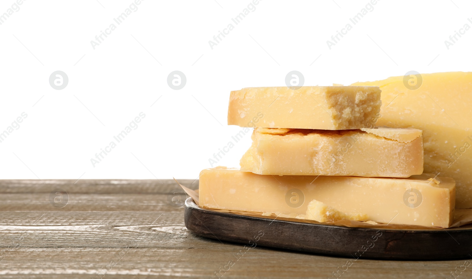 Photo of Pieces of delicious parmesan cheese on wooden table against white background. Space for text