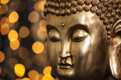 Photo of Buddha statue against blurred lights, closeup. Space for text