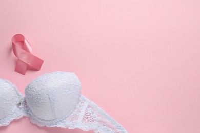 Photo of Pink ribbon and bra on color background, top view with space for text. Breast cancer awareness
