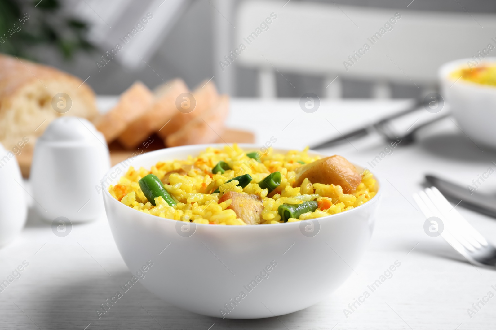 Photo of Delicious rice pilaf with meat served on white table