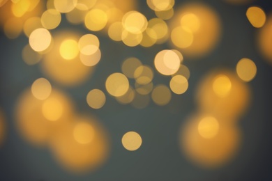 Photo of Blurred view of gold lights on dark background. Bokeh effect